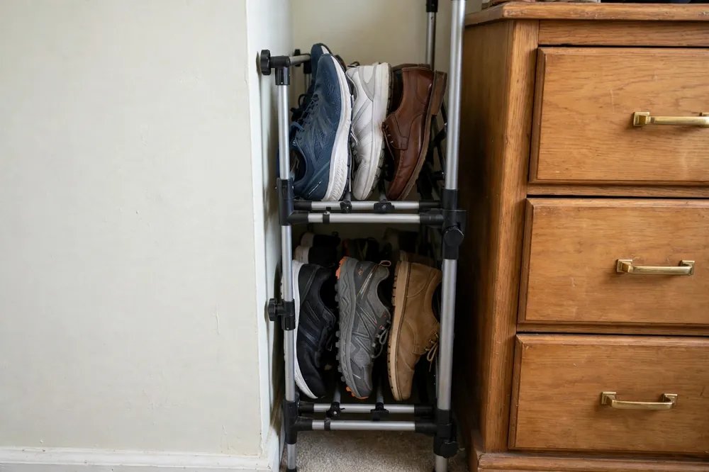 Expandable shoe rack adjusted to fit a narrow closet gap between a wall and a dresser